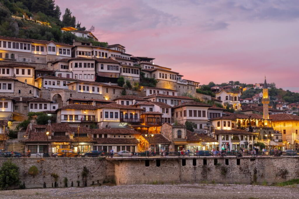 Shtëpitë e Mangalemit në Berat në muzg, me minaren dhe muret e gurta buzë lumit Osum