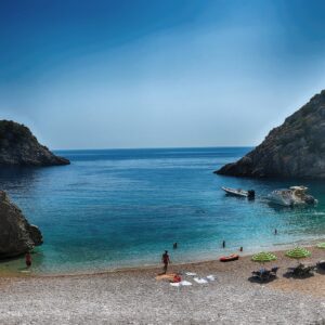 La baie de Grama à Karaburun, avec ses eaux bleues, ses bateaux et ses hautes falaises.